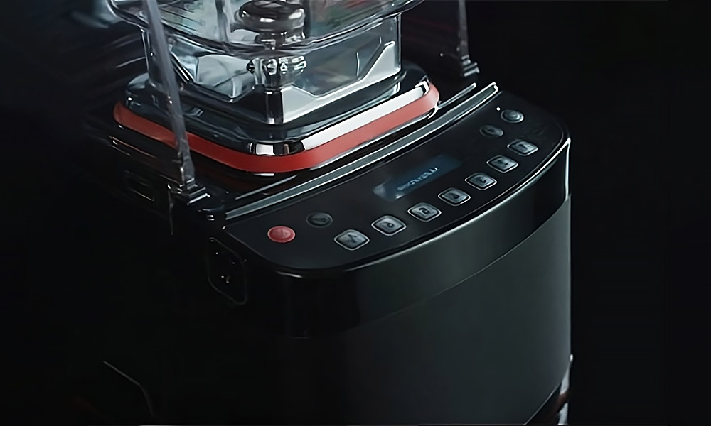 Blendtec Stealth 885 sat on a countertop next to glass of juice